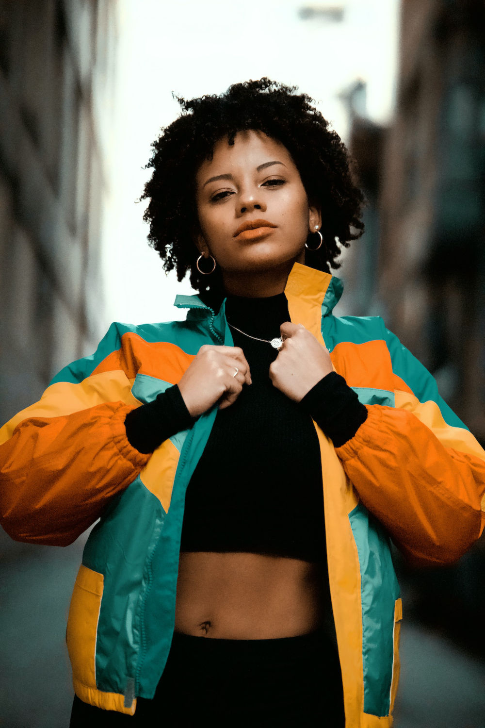 Woman posing for a photo wearing a colorful bomber jacket